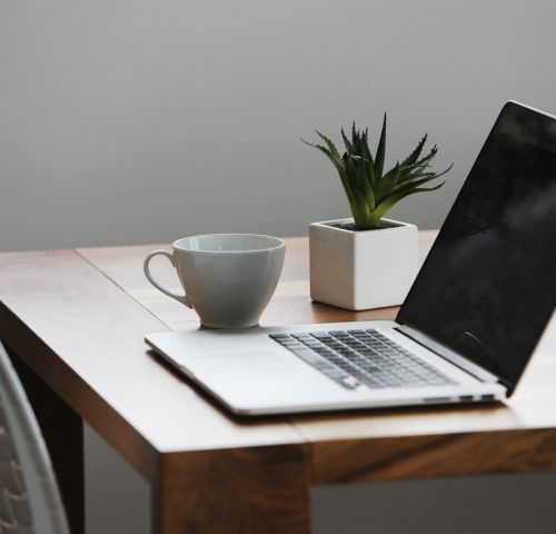 silver-laptop-computer-next-to-ceramic-cup-42408